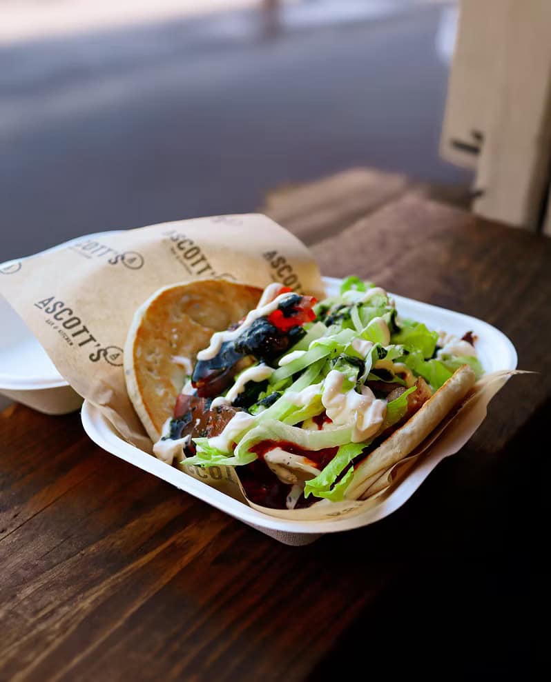 Delicious burger served with fresh vegetables and a slice of lemon, perfect for a casual dining expe.