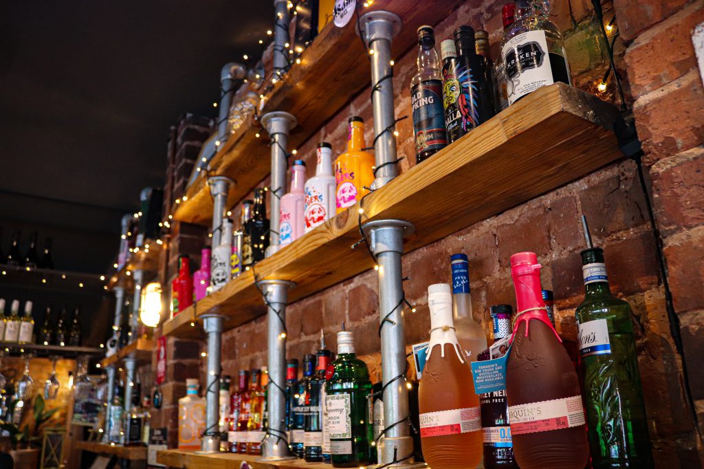 Brightly lit bar shelves with colourful bottles at Ascotts Restaurant.