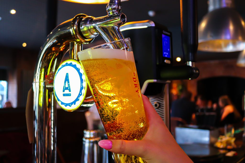 Pouring craft beer at Ascotts Restaurant, Bromsgrove, with a lively bar setting.