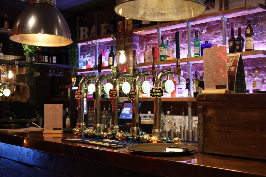 Modern sports bar with beer taps and vibrant lighting at Ascotts Bromsgrove.